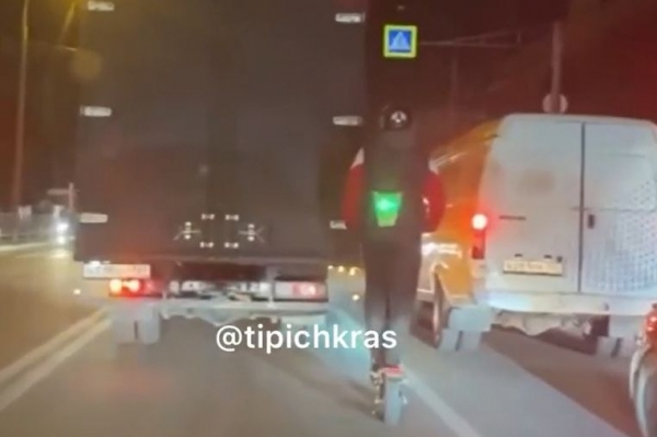 Мужчина на самокате со светофором на спине поразил водителей Краснодара